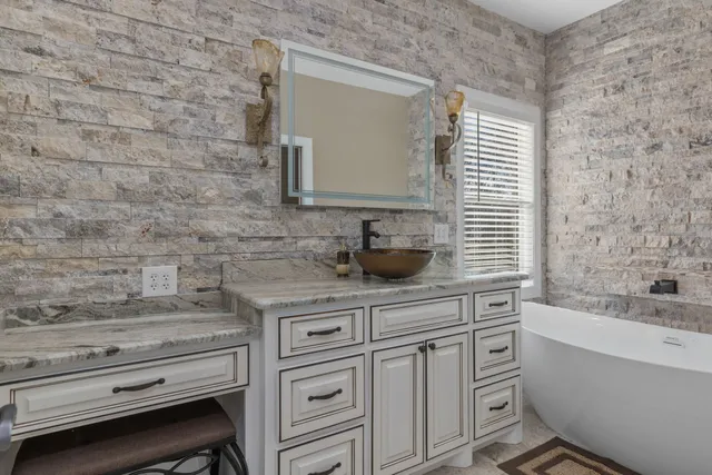 a bathroom with a granite countertop sink a toilet and bathtub