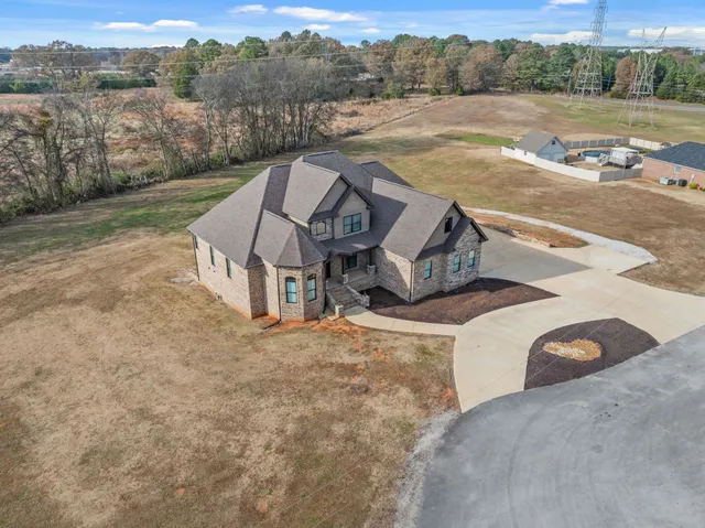 an aerial view of a house with pool and a yard