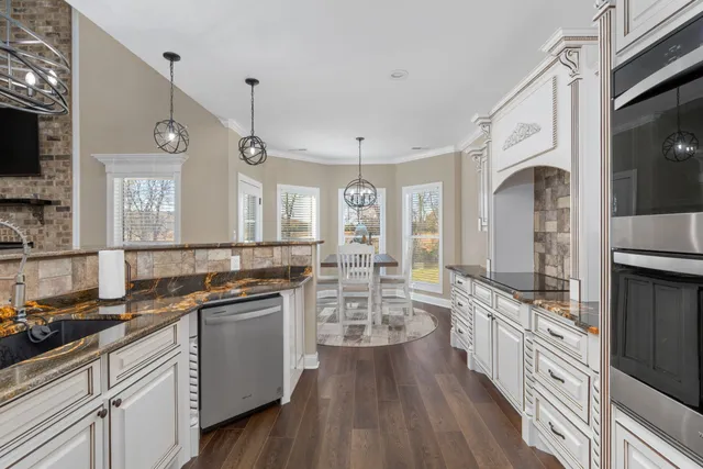 a large kitchen with a lot of counter space and wooden floor