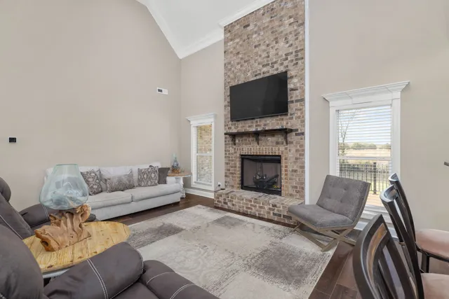 a living room with furniture a flat screen tv and a fireplace