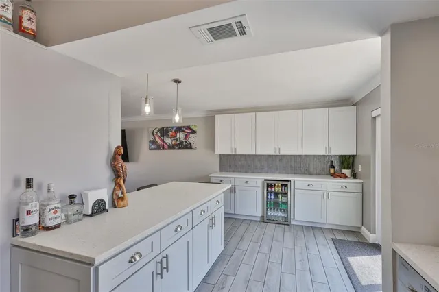 a kitchen with a sink dishwasher stove and white cabinets with wooden floor