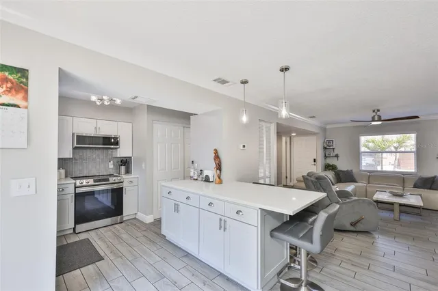 a kitchen with stainless steel appliances granite countertop a stove top oven a sink and a refrigerator