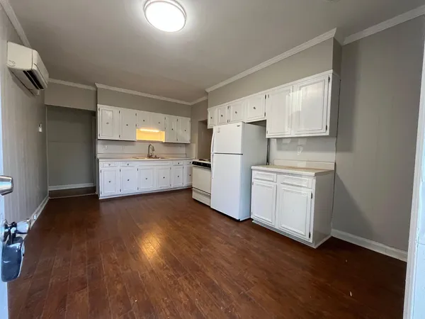 a kitchen with wooden floors and white appliances