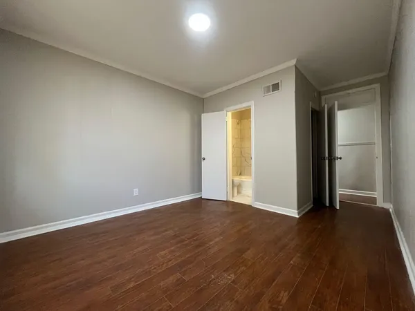 a view of an empty room with wooden floor