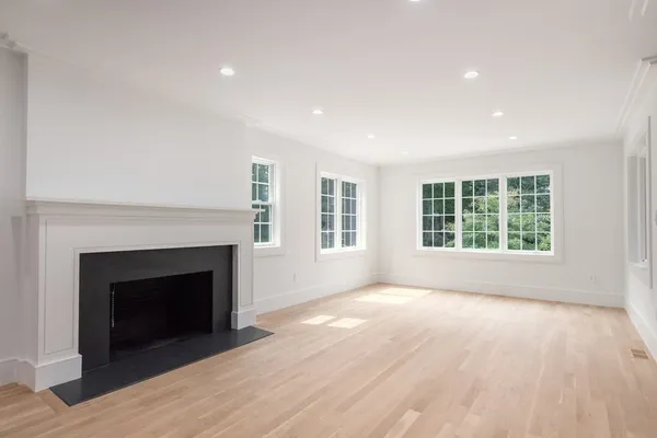 a view of an empty room with windows and a fireplace