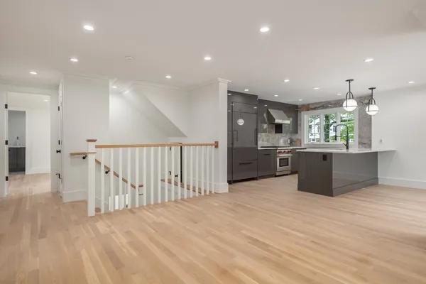 a large kitchen with stainless steel appliances kitchen island a large counter top and a wooden floors