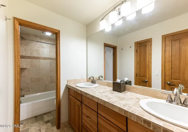 a bathroom with a tub a sink and a mirror