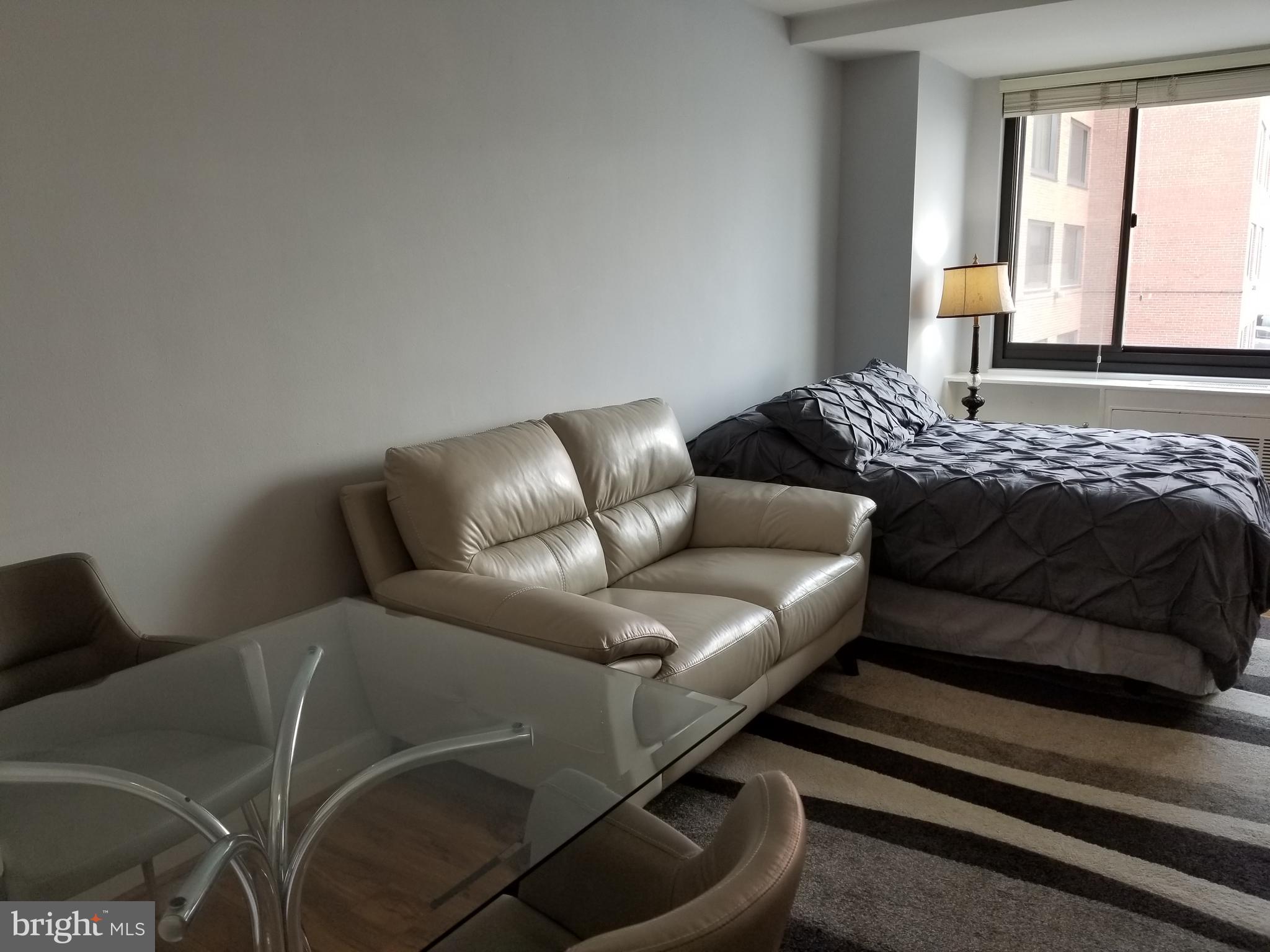 1021 Arlington Boulevard, Unit 414 Arlington, VA 22209 - Photo 5 of 31 a bed room with a bed and a couch