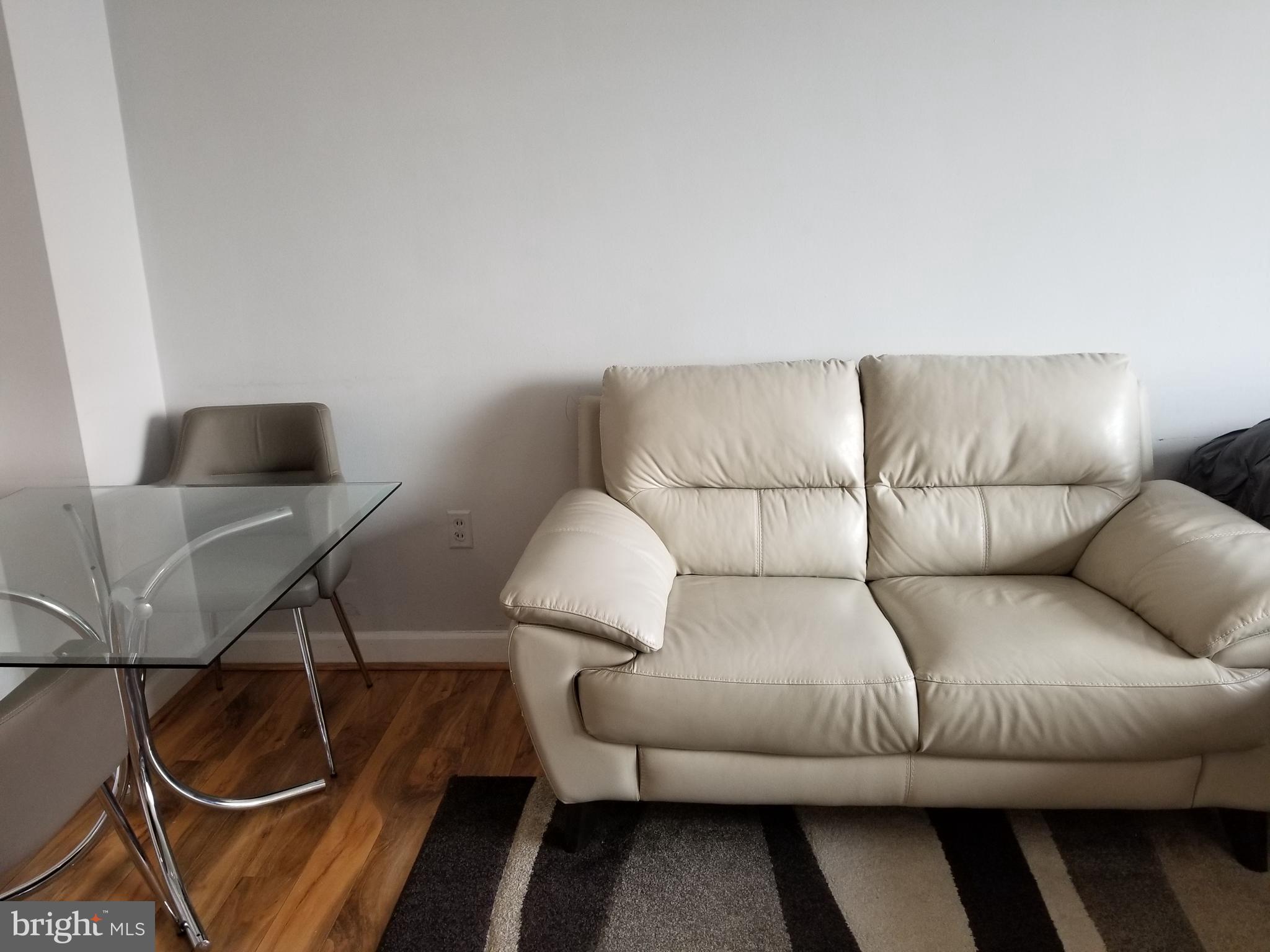 1021 Arlington Boulevard, Unit 414 Arlington, VA 22209 - Photo 9 of 31 a living room with furniture and a lamp