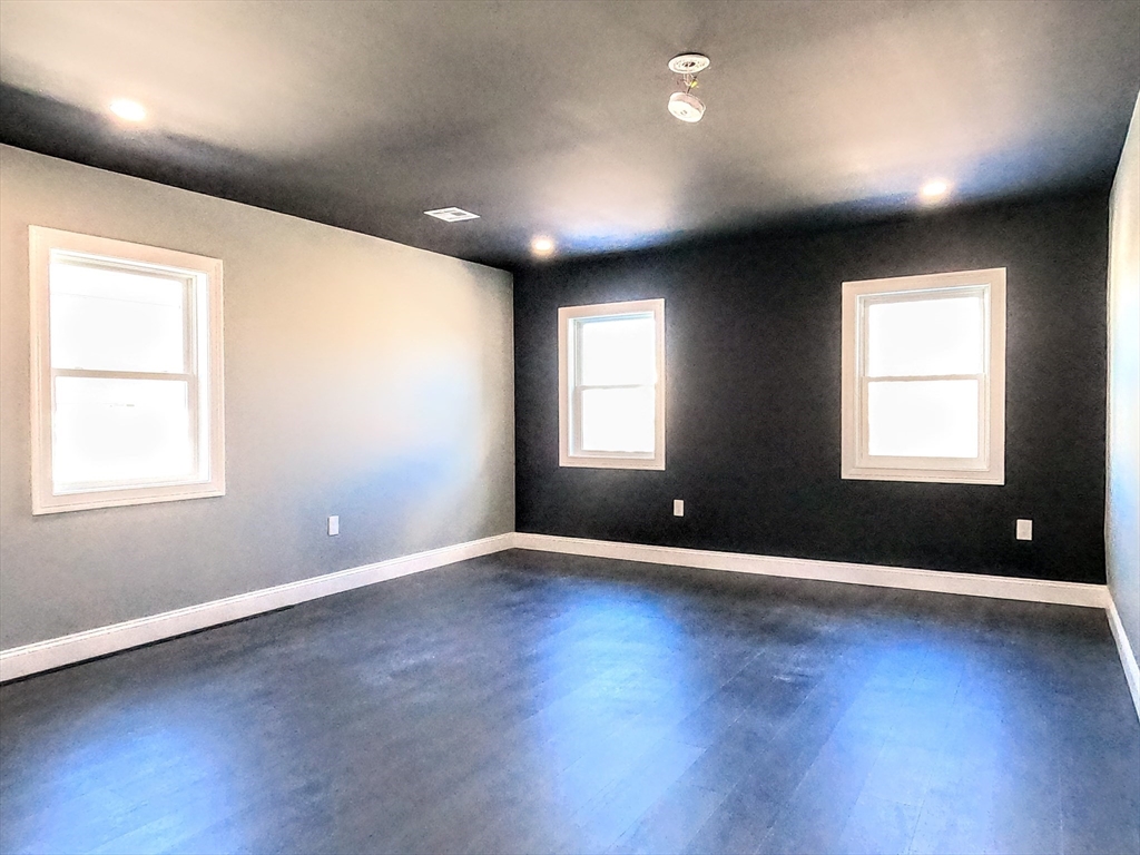 2 Sunnyside Street, Unit 2 Boston, MA 02130 - Photo 17 of 41 an empty room with wooden floor and windows