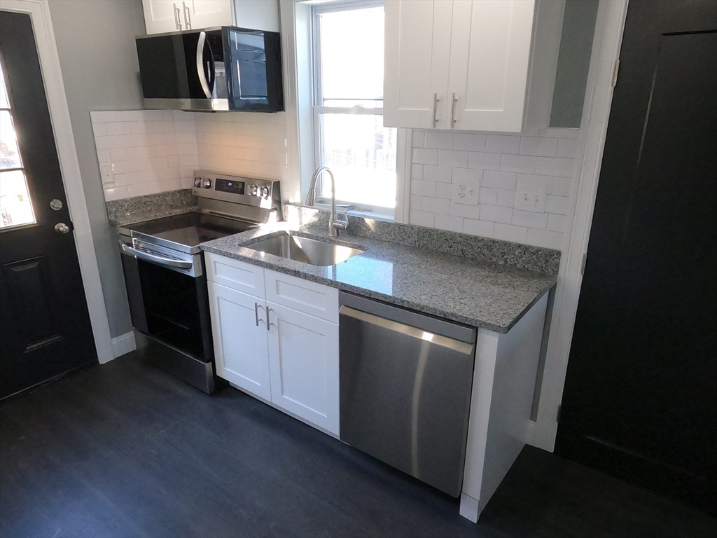 2 Sunnyside Street, Unit 2 Boston, MA 02130 - Photo 19 of 41 a kitchen with stainless steel appliances granite countertop a sink stove and microwave