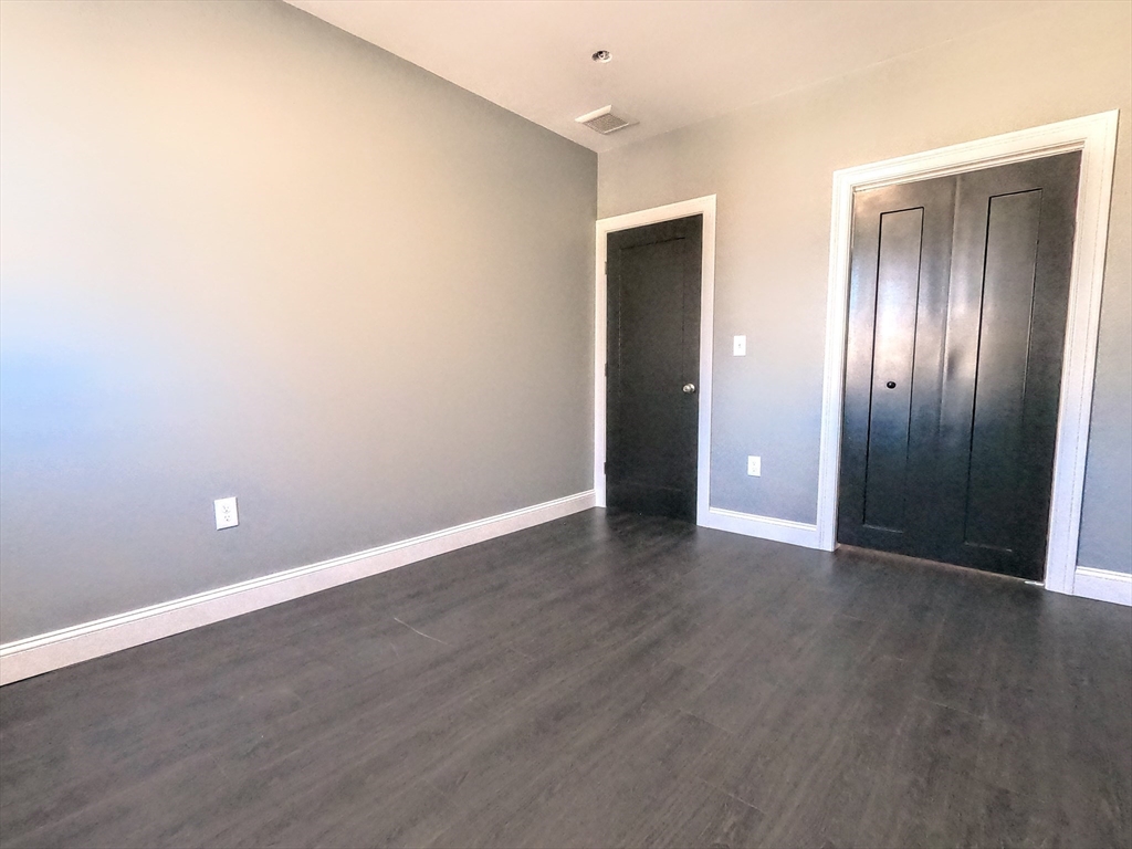 2 Sunnyside Street, Unit 2 Boston, MA 02130 - Photo 35 of 41 an empty room with wooden floor & windows
