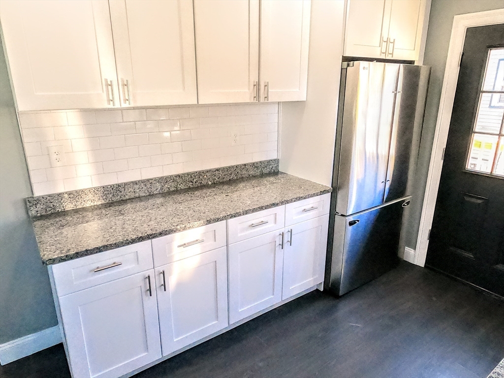 2 Sunnyside Street, Unit 2 Boston, MA 02130 - Photo 7 of 41 a kitchen with granite countertop white cabinets and refrigerator