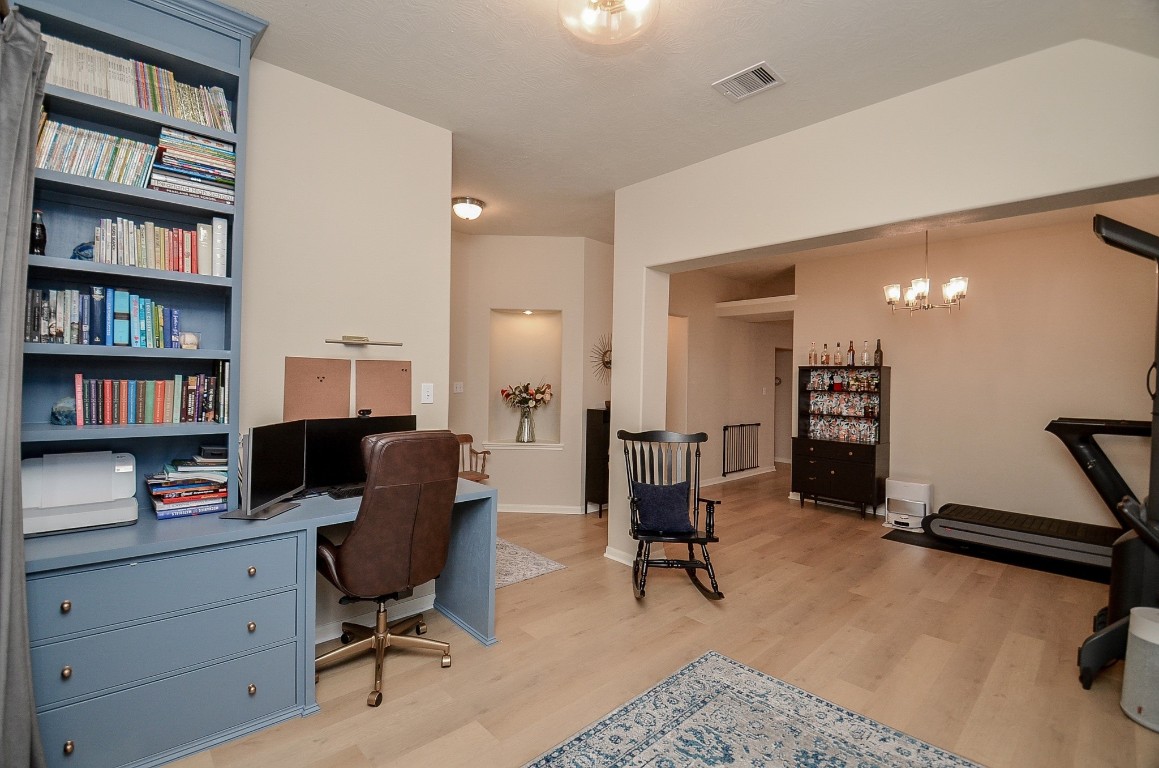9222 Sorrell Hollow Lane Rosenberg, TX 77469 - Photo 14 of 46 Versatile front room with custom built-ins and office setup, offering a seamless blend of functionality and flexibility with easy access to the main living spaces.