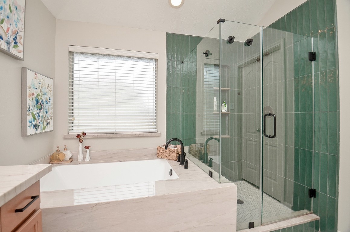 9222 Sorrell Hollow Lane Rosenberg, TX 77469 - Photo 34 of 46 Spacious primary bath with a dual vanity, separate soaking tub, and glass-enclosed walk-in shower with stylish tile surround.