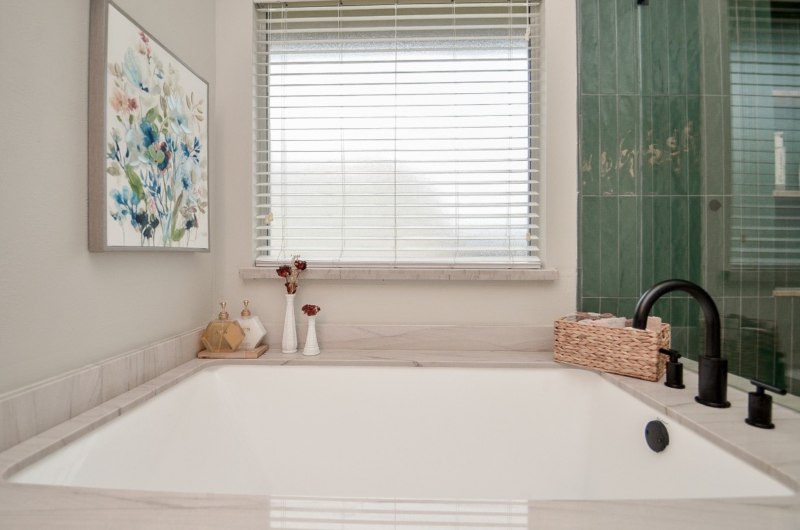 9222 Sorrell Hollow Lane Rosenberg, TX 77469 - Photo 35 of 46 Inviting soaking tub positioned beneath a window, creating a bright and calming space to relax.