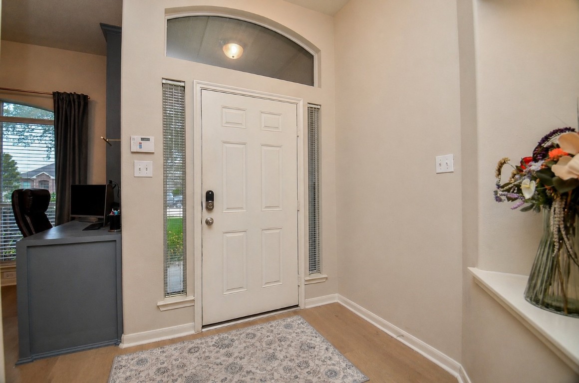 9222 Sorrell Hollow Lane Rosenberg, TX 77469 - Photo 4 of 46 Bright and welcoming entry featuring transom and sidelights that bring in natural light, complemented by durable LVP flooring installed in 2025.