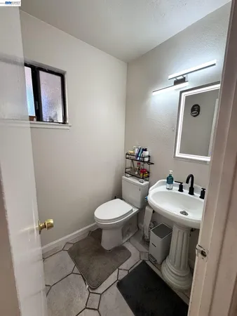 a bathroom with a sink toilet and mirror