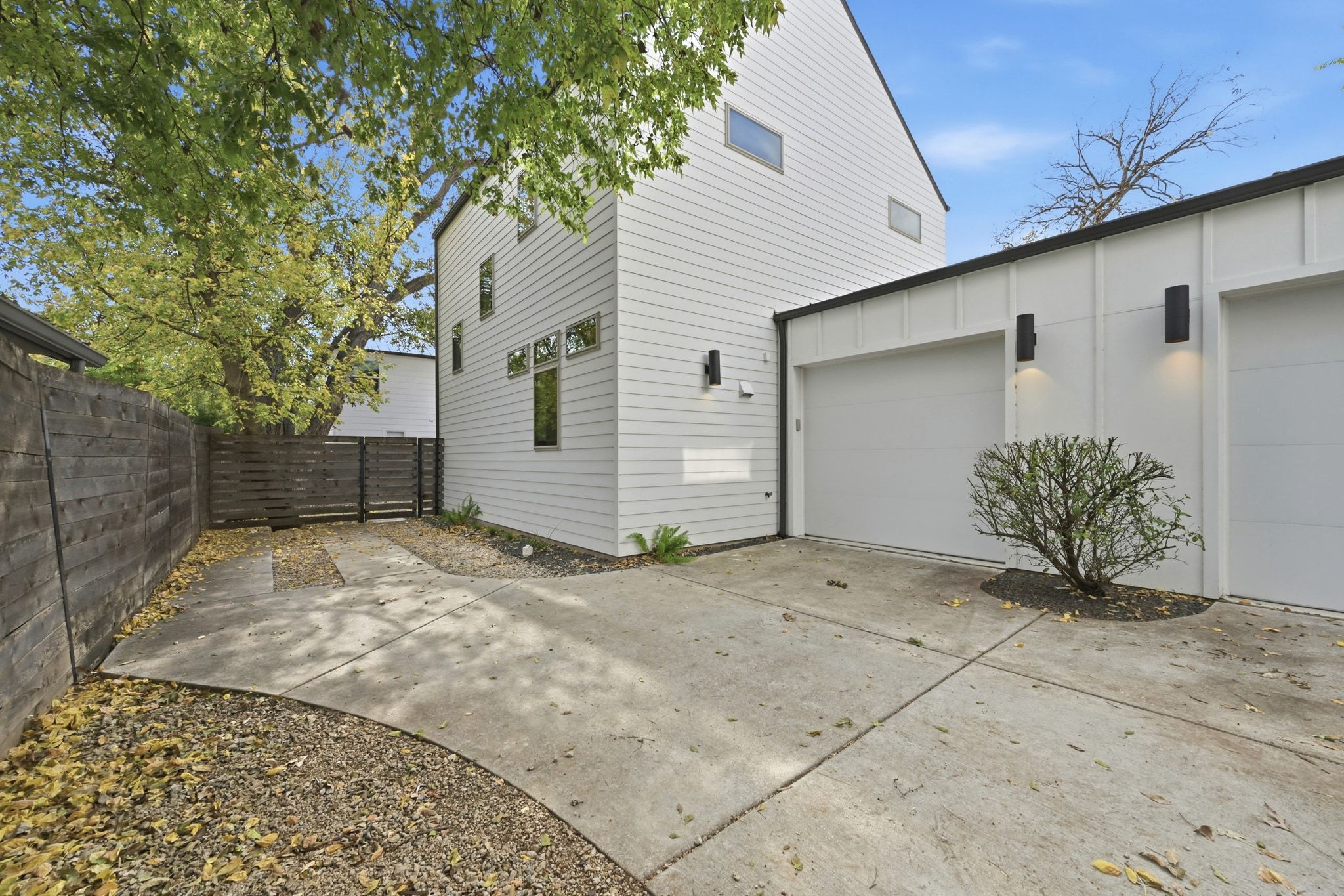 2811 Garwood Street, Unit B Austin, TX 78702 - Photo 3 of 24 View of side of home with a patio area, concrete driveway, and board and batten siding