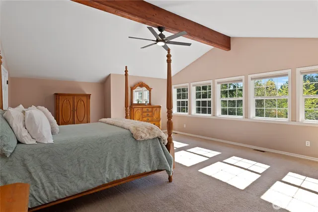 a bedroom with a large bed and wooden floor
