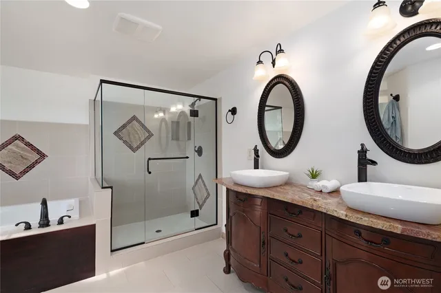 a bathroom with a granite countertop double vanity sink and a mirror