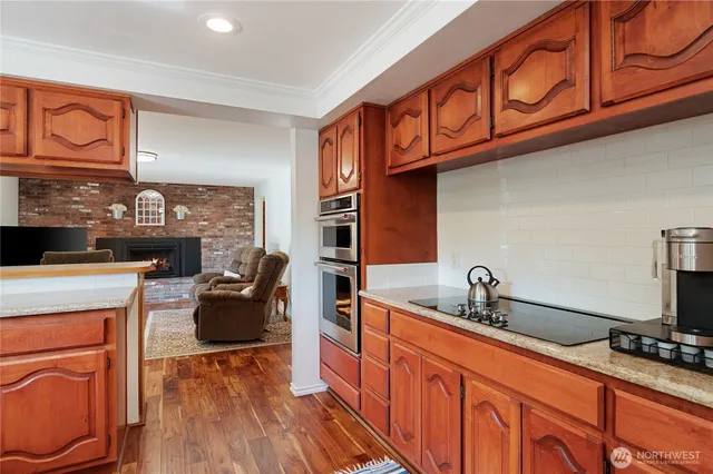 a kitchen with stainless steel appliances granite countertop a stove a sink and a refrigerator