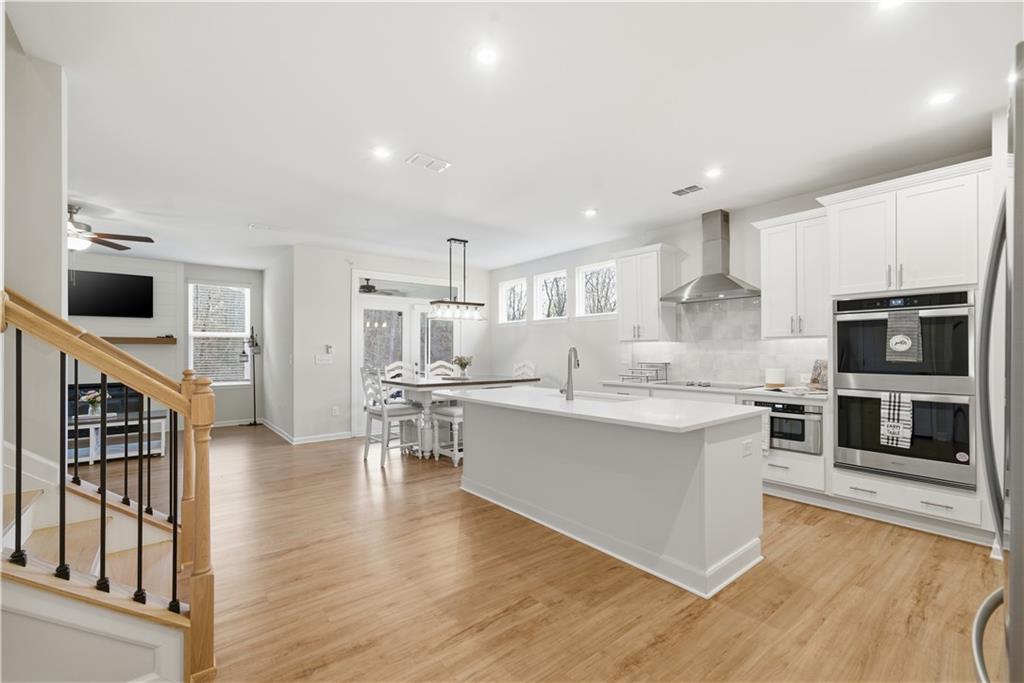15 Parkside View Cartersville, GA 30121 - Photo 12 of 49 a large kitchen with stainless steel appliances a stove a sink dishwasher a microwave oven and a dining table with wooden floor