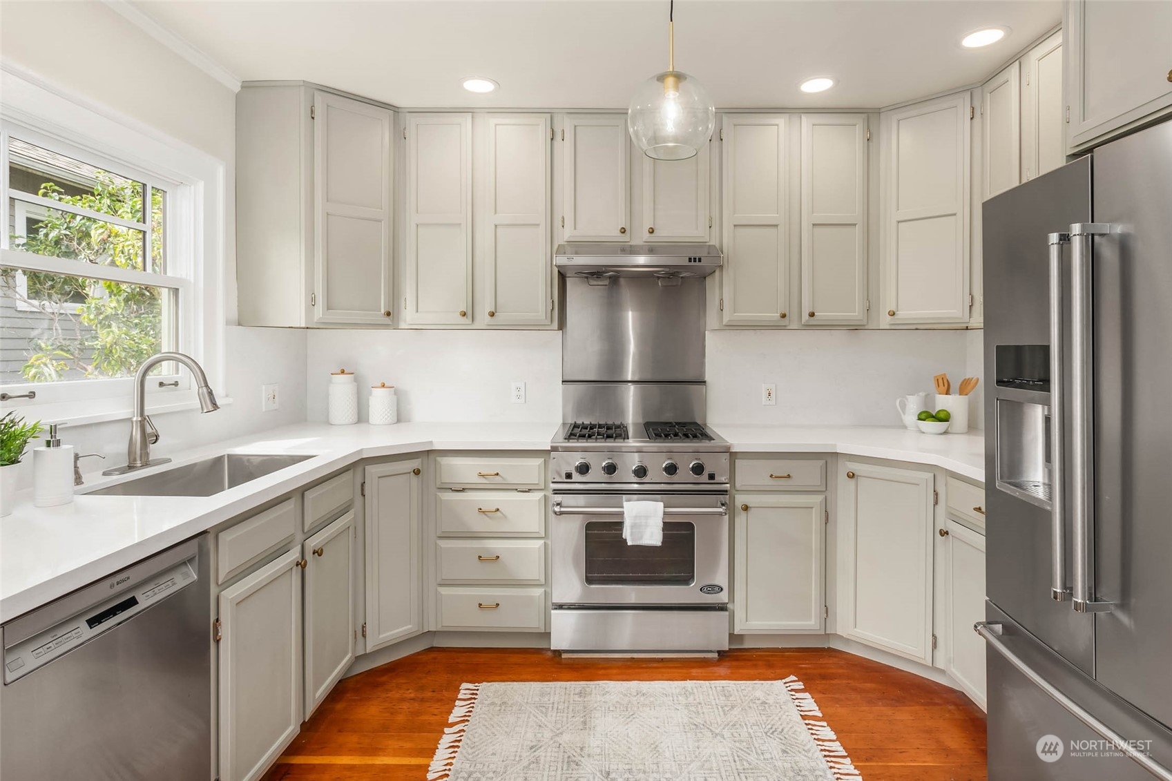 2368 North 52nd Street Seattle, WA 98103 - Photo 11 of 32 a kitchen with stainless steel appliances granite countertop a stove a sink dishwasher and a refrigerator with wooden cabinets