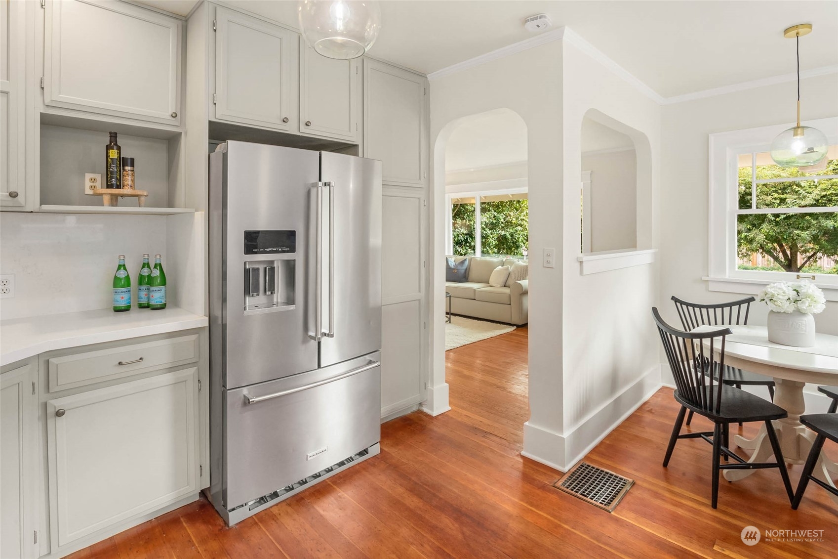 2368 North 52nd Street Seattle, WA 98103 - Photo 13 of 32 a kitchen with stainless steel appliances a refrigerator a stove a dining table and chairs with wooden floor