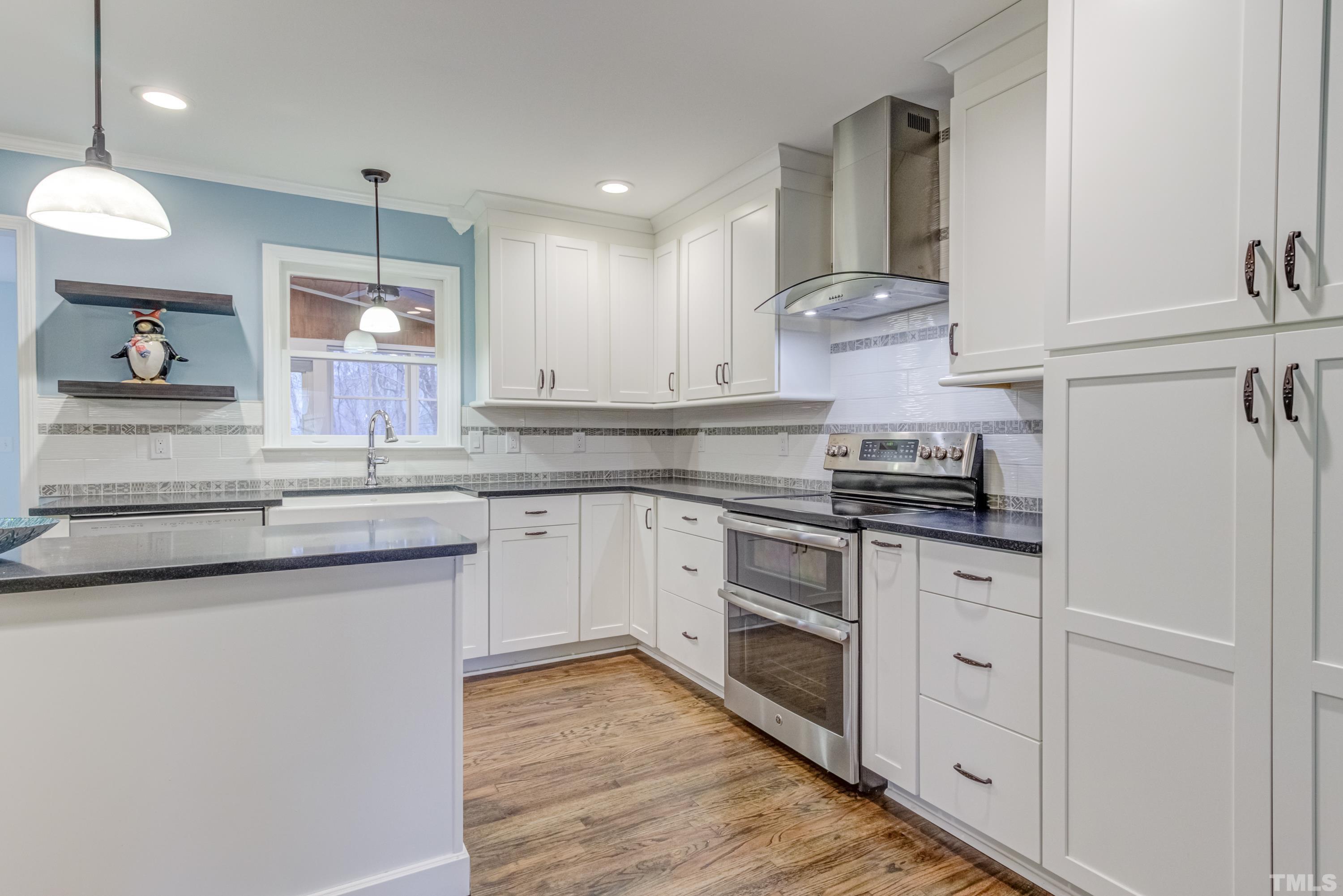 605 Jordan Ridge Lane Raleigh, NC 27603 - Photo 12 of 36 a kitchen with kitchen island granite countertop a sink cabinets and stainless steel appliances