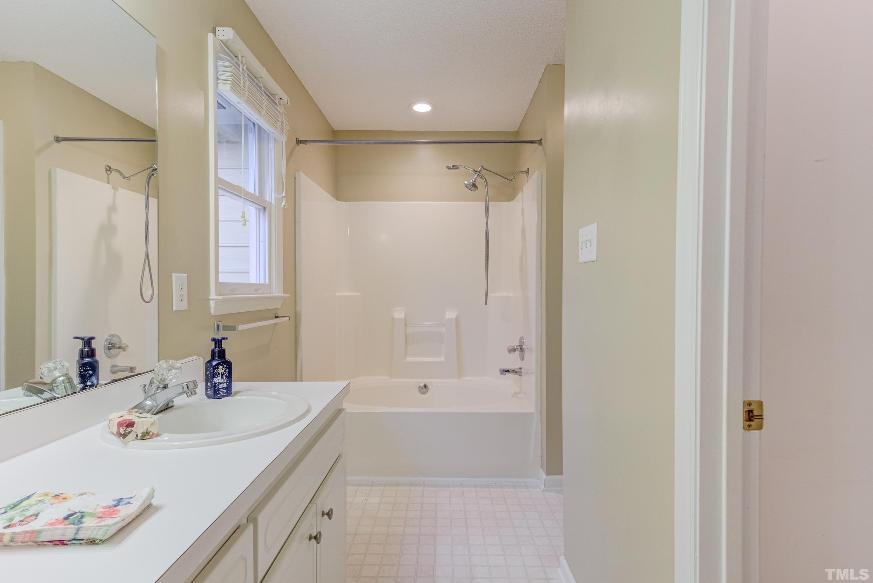605 Jordan Ridge Lane Raleigh, NC 27603 - Photo 19 of 36 a bathroom with a tub sink and mirror