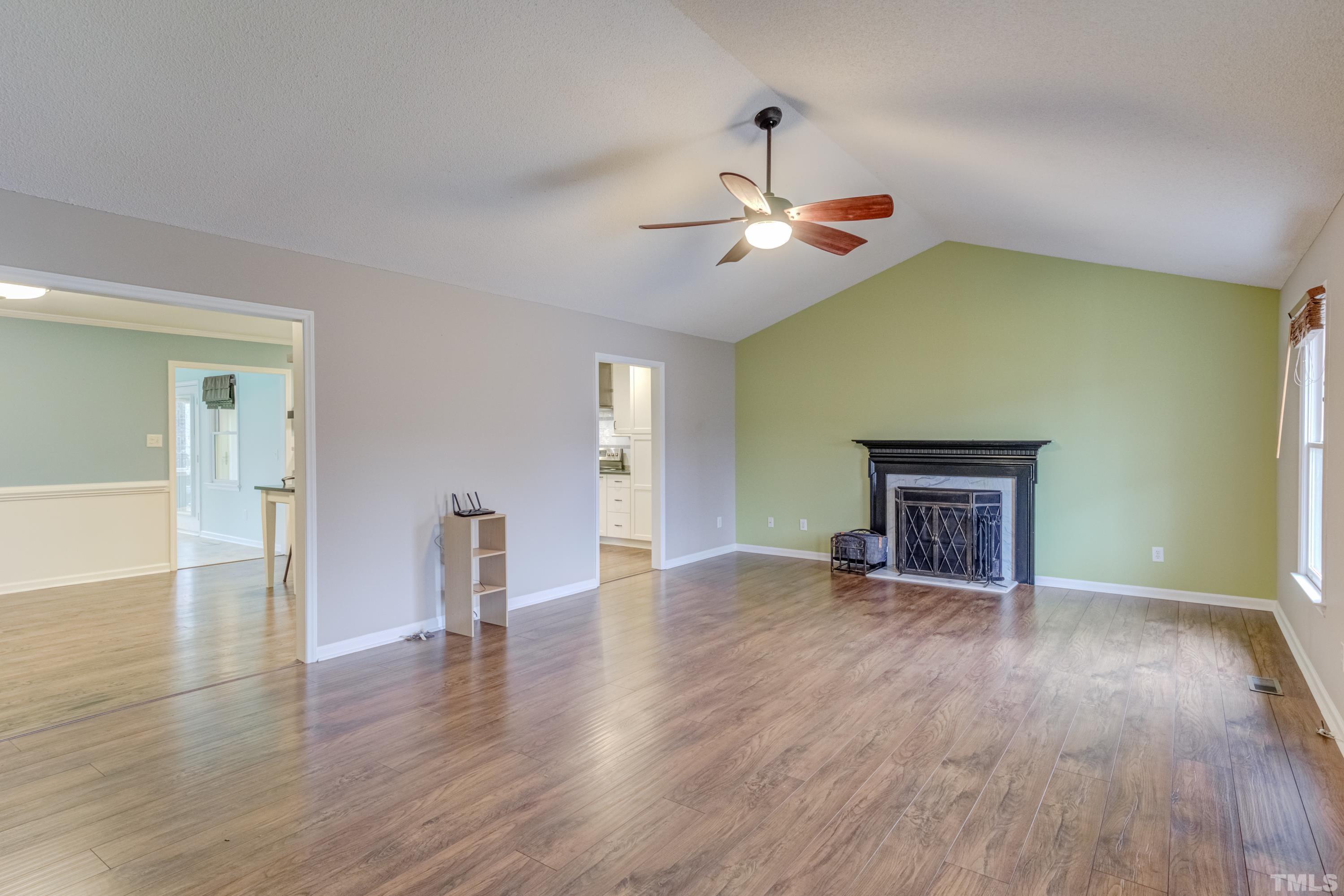 605 Jordan Ridge Lane Raleigh, NC 27603 - Photo 4 of 36 a view of an empty room with wooden floor and a ceiling fan