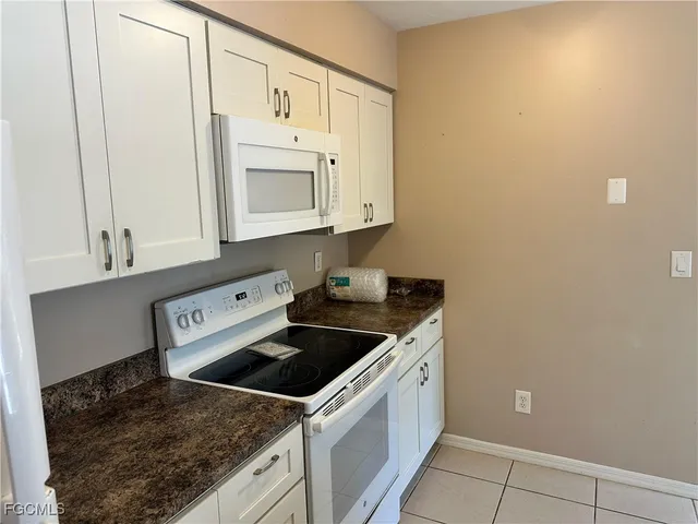 a kitchen with white cabinets and white appliances