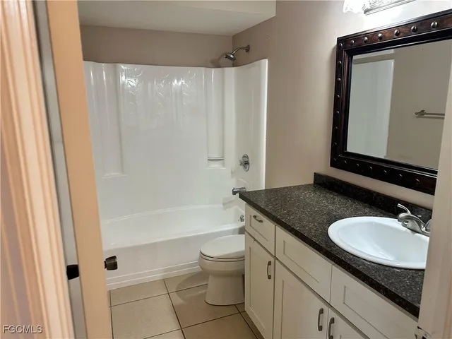 a bathroom with a granite countertop sink toilet and shower a bathtub