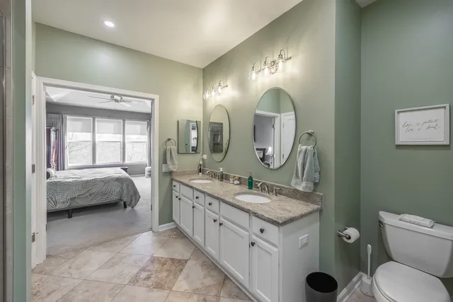a en suite bathroom with a double vanity sink and a mirror