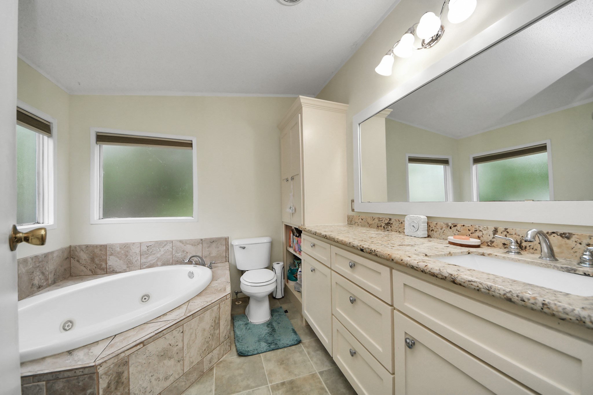 204 Edith Street Highlands, TX 77562 - Photo 13 of 33 a bathroom with a granite countertop sink mirror bathtub and toilet