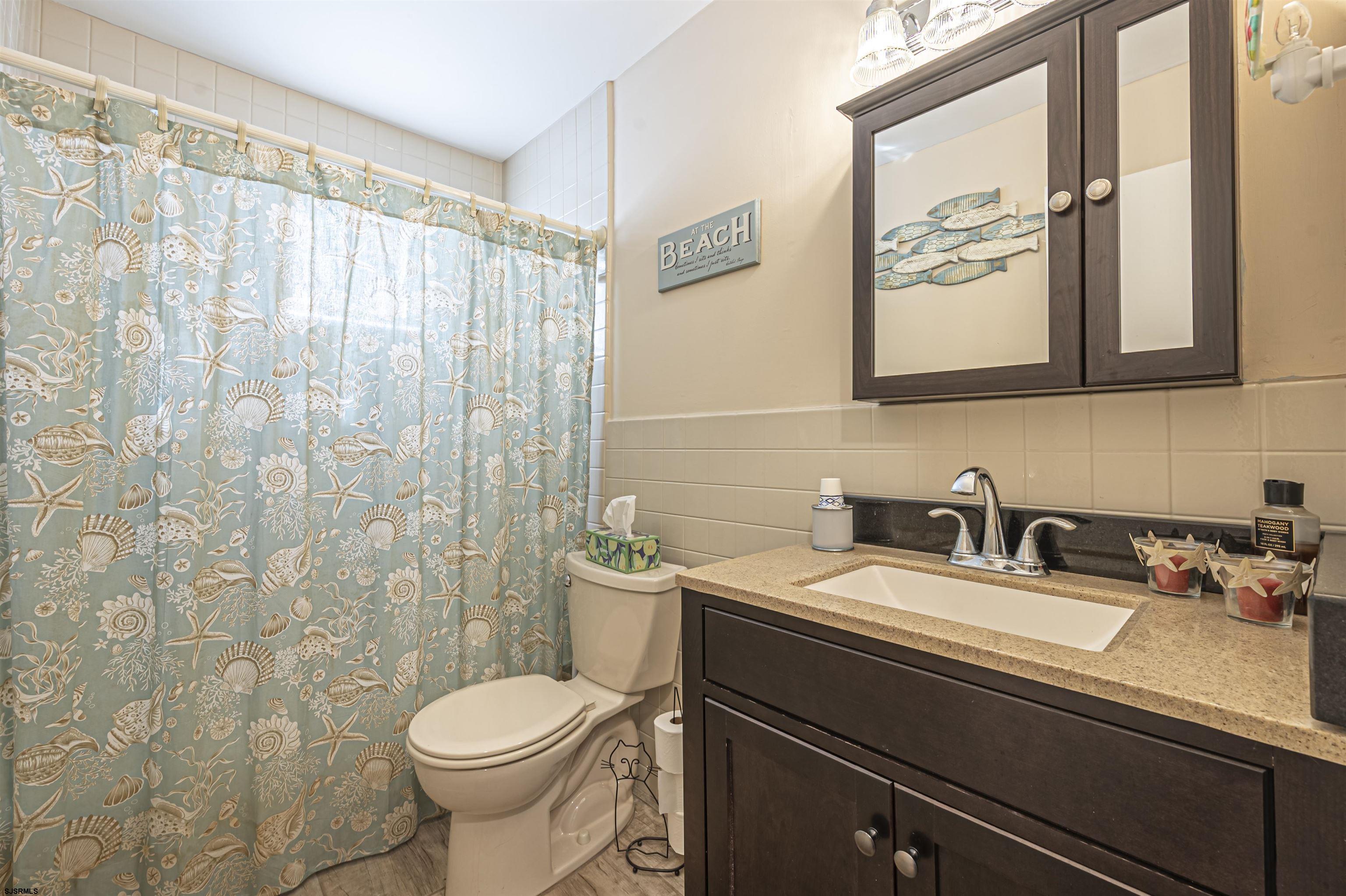 4901 Harbor Beach Boulevard, Unit Q3 Brigantine, NJ 08203 - Photo 13 of 19 a bathroom with a sink a toilet and a mirror