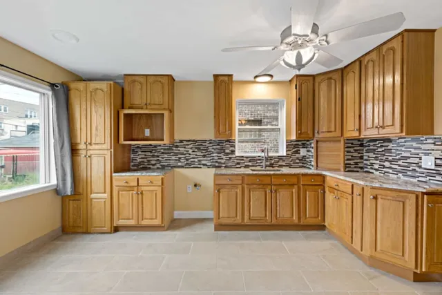 a spacious bathroom with a granite countertop sink mirror and a bathtub
