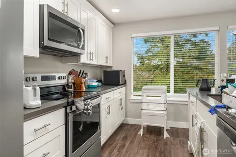 a kitchen with stainless steel appliances a stove sink microwave and cabinets