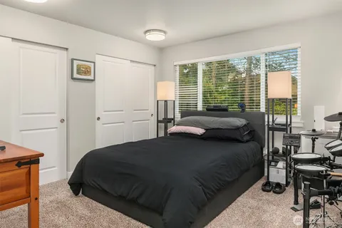 a bedroom with a bed and large windows