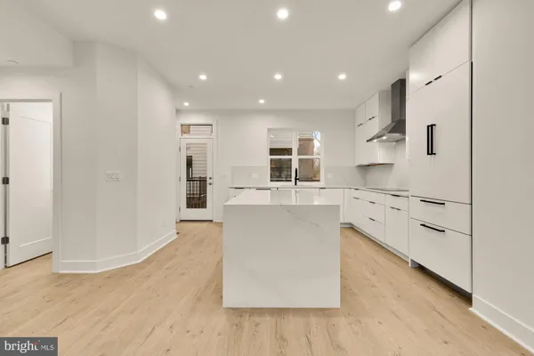 a large white kitchen with stainless steel appliances