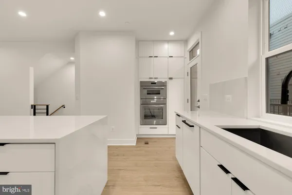 a kitchen with granite countertop white cabinets and a sink