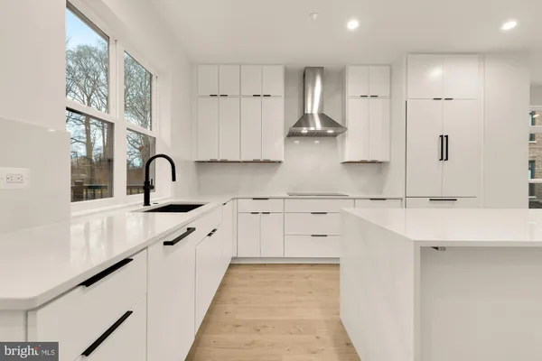 a large kitchen with stainless steel appliances a large counter top a stove and a refrigerator