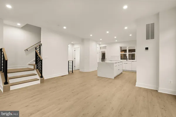 a view of an empty room with stairs and a window