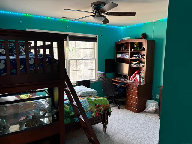 a bedroom with a bed and a flat tv screen on dresser
