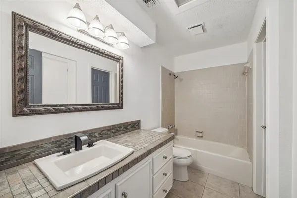 a bathroom with a sink a toilet a mirror and shower