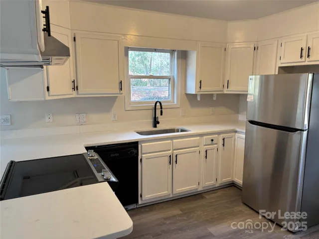 a kitchen with a sink a refrigerator and cabinets