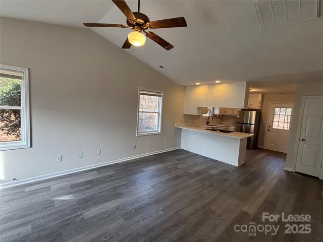 a view of a kitchen with wooden floor and a window