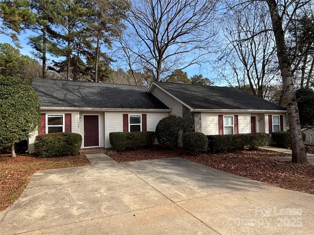 a front view of a house with a yard and trees