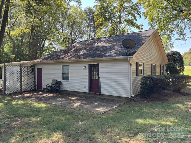 a view of a house with a yard and large tree